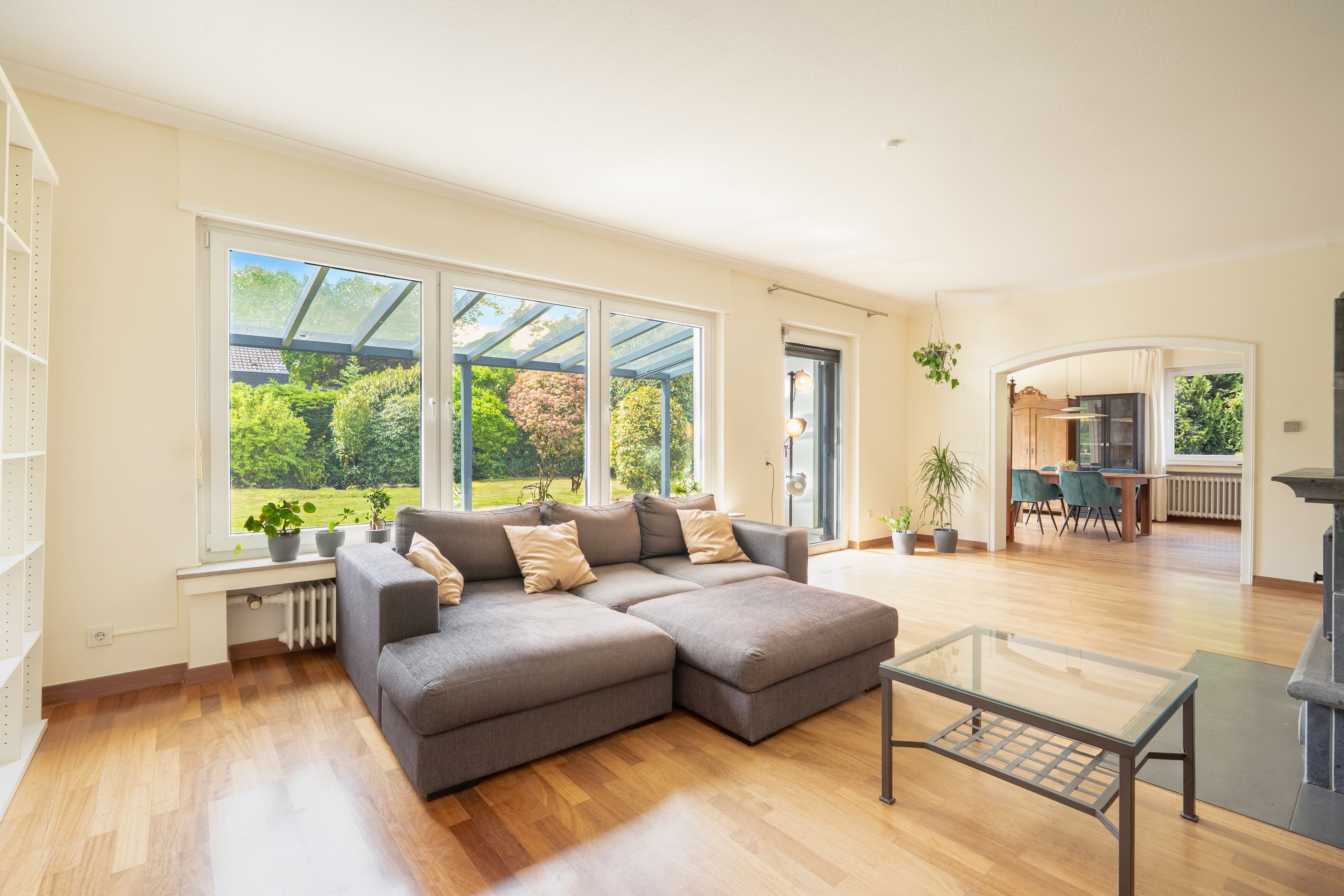 Helles offenes Wohnzimmer mit großem Sofa und Gartenblick